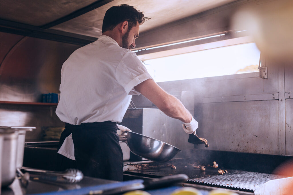 man working inside of a food truck